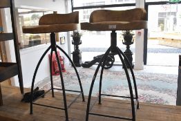 A pair of rustic Industrial bar stools having wrought iron frames