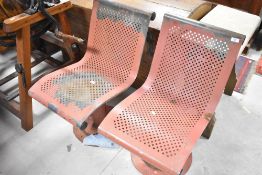 A pair of metal seats, possibly railway station or bus stop related