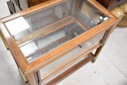 A late Victorian or Edwardian mahogany bijoutuerie table having inlaid decoration and lift sides,