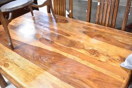A modern hardwood dining table and two chairs