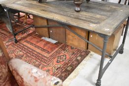 An Industrial style table having plank top and metal frame, with castors, approx. 183 x 91cm