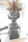 A pair of cast iron campana style garden urns on classical style plinth , in the Victorian style,