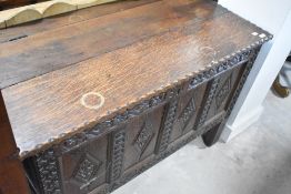 A 19th Century oak kist having pie crust lid and carved panel decoration, with monogram SL, width