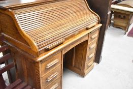 An early 20th Century oak roll top desk, width approx. 122cm