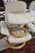 A Stressless swivel cream leather armchair and a complimentary footstool