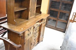 A late 19th or early 20th Century oak sideboard/music cabinet (drop flaps to drawers), width approx.