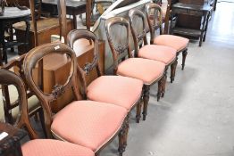 A set of six Victorian mahogany balloon back dining chairs with later upholstery to overstuffed