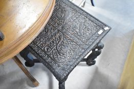 An Asian carved occasional table having reptilian decoration and elephant supports, approx. 46 x