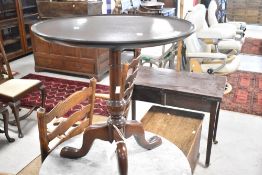 A reproduction mahogany occasional table having circular top on turned column and triple splay legs,