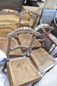 A set of four Regency style rail back dining chairs having canework seats and fluted legs