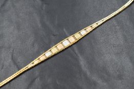 A 1980's three coloured 9ct gold, shaped bracelet having central panels with snake link style