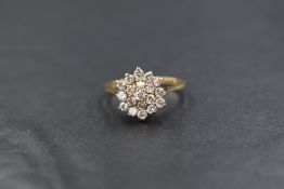 A 9ct gold triple cluster ring having clear paste stones in a raised claw set mount on a pct gold