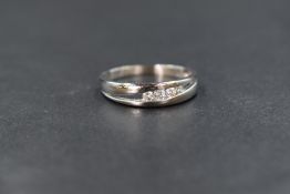 A 14ct white gold ring having four channel set cubic zirconia stones in an open mount on a white