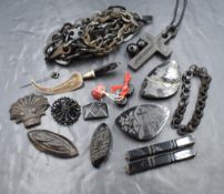 A selection of jet mourning jewellery etc including a chain, carved panels, one of Whitby Abbey, a