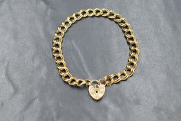 A 9ct gold double curb link bracelet, marked 375 with a 9ct gold heart padlock marked 375, 11.7g