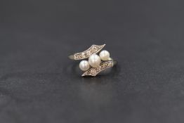An Edwardian 18ct white gold pearl and diamond set ring, the three central graduated pearls having a