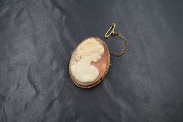 A 9ct gold mounted cameo brooch, the shell cameo depicting a maiden in profile in a bezel setting
