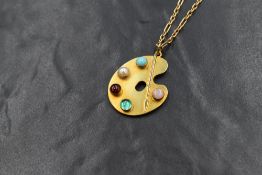 A 9ct gold modern gemstone set necklace, the paint pallet design pendant set with turquoise,