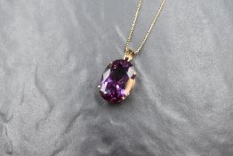 A 14ct gold purple gemstone possibly synthetic alexandrite set pendant, marked 14K, the oval cut