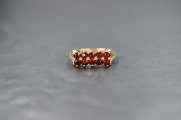 A 9ct gold garnet set ring, the two rows of five round cut garnets in claw settings with split