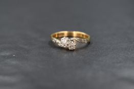An 18ct gold two stone diamond ring, having two 0.128ct stones in a crossover setting to diamond