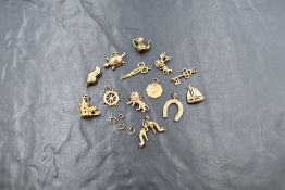 Thirteen 9ct gold loose charms of various themes including yacht, lion, stilettos, etc, approx 18.
