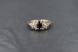 A 9ct gold sapphire and diamond set ring, the central oval cut sapphire measuring approximately 0.