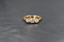 An 18ct gold diamond set trilogy ring, the graduated round brilliant cut diamonds measuring