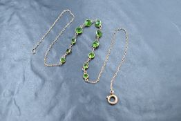 A yellow metal necklace having eleven diopside style collared stones on a fixed chain, approx