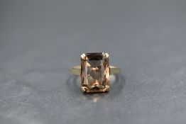 A 9ct gold smoky quartz set dress ring, the emerald cut smoky quartz, measuring approximately 13.4mm
