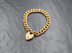 A 15ct gold padlock bracelet, the curb link bracelet having alternating plain and engraved links,