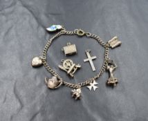 A white metal charm bracelet, having seven charms with an additional three being loose, including an