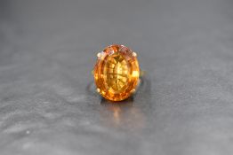 A yellow metal citrine ring, having a large oval cut Citrine, measuring approximately 18mm x 15mm in
