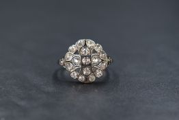 An 18ct white gold diamond set plaque ring, the nineteen old cut diamonds in a circular pierced