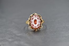A 9ct gold cameo set ring, the cameo depicting a decorative scroll border with a central vacant