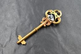 A yellow metal key, having an enamelled yellow, black and white coat of arms to the front with a 9ct