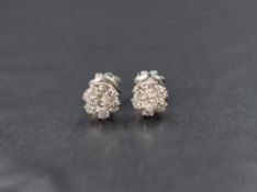 A pair of white metal presumed white gold diamond set cluster stud earrings, the central round