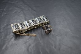 A Siamese silver articulated panel bracelet with black enamel engraved figured panels and