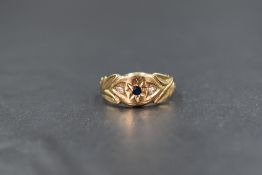 A 9ct gold gypsy style ring having a small central sapphire flanked by two diamond chips in a
