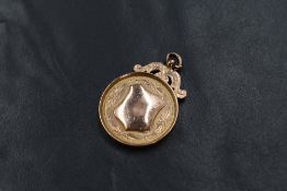 A 9ct rose gold medallion, having a vacant shield and personalised engraving to the reverse,