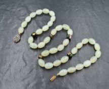 A string of Chinese oval jadeite beads interspersed by five cloisonné decorative beads and having an