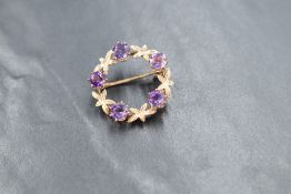 A 9ct gold wreath brooch having amethyst and foliate decoration, approx 28mm diameter & 5g