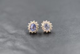 A pair of 9ct gold sapphire and diamond set cluster stud earrings, the central oval cut sapphires
