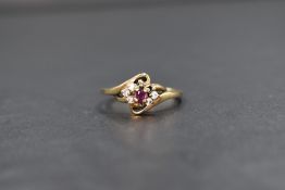 A 9ct gold ruby and cubic zirconia cluster ring, the central marquise cut ruby flanked by three