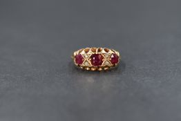 An 18ct gold ruby and diamond set ring, the three graduated cushion style cut rubies interspersed