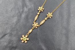 A 15ct gold peridot and seed pearl set necklace, the four round bezel millegrain mounted peridots