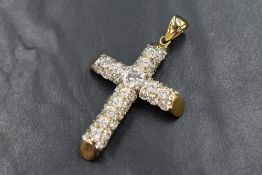 A large 9ct gold cross pendant of hollow form being encrusted with cubic zirconia stones, size