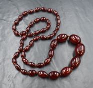 A long knotted string of cherry amber beads, the front eleven beads being graduated, no clasp,
