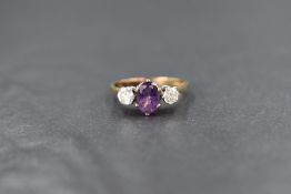 A 9ct gold amethyst and cubic zirconia ring having a central oval amethyst flanked by two cubic