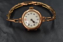 A vintage 9ct rose gold wrist watch having an Arabic numeral dial to white enamelled face in a plain